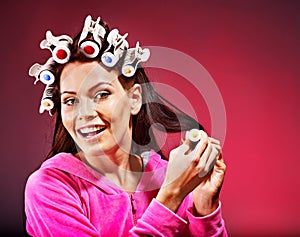 Woman wear hair curlers on head.