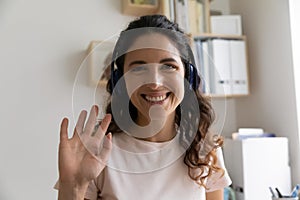Woman wear headphones greeting friend start videoconference