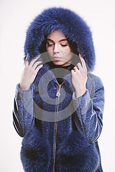 Woman wear hood with fur. Fashion concept. Girl elegant lady wear fashionable coat jacket with furry hood. Luxurious fur