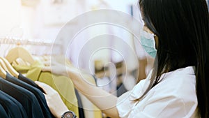 Woman wear protective mask shopping in clothing store