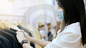 Woman wear protective mask shopping in clothing store