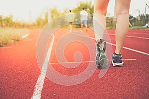 Woman wear sport shoe on to run in running court background.