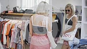 Woman wear the white dress in the checkroom. Fashionable european girl looking in the mirror in fitting room. Young and