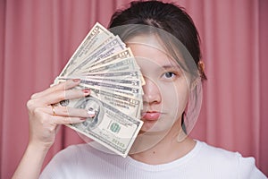 woman wear white shirt a angry frown and counting holding in hand banknotes or money us dollar exchange money