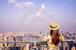 Woman wear yellow dress and hat, Asian traveler standing with their backs turned and looking aside on balcony with beautiful