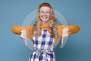 Woman wearing apron smiling and looking at camera pointing with two hands