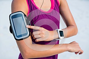 Woman wearing arm band and smart watch at beach