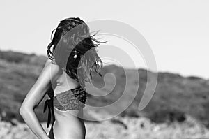 Woman wearing bikini while standing against clear blue sky. Freedom concept. Santa Teresa Gallura, Sardinia, Italy