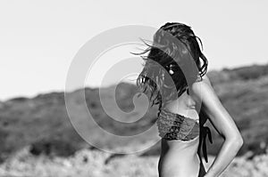 Woman wearing bikini while standing against clear blue sky. Freedom concept. Santa Teresa Gallura, Sardinia, Italy