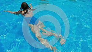 Woman wearing bikini swimming in pool on vacation