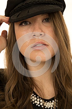 Woman wearing black hat looking at camera somber look