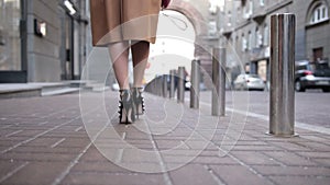 Woman wearing black high heels shoes walking away