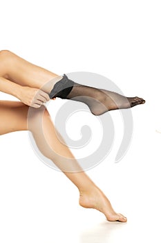 Woman wearing black short nylon socks on white