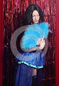 Woman Wearing Blue Corset Preforming Burlesque Dance With Feather Fan