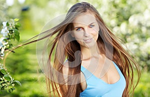 Woman wearing blue dress over spring orchard