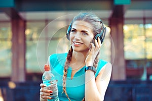 Woman wearing blue green sport-wear enjoy music on headphones