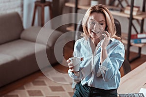 Woman wearing blue shirt receiving call from her colleague