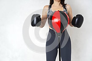 Woman wearing boxing gloves near the floor punching bag