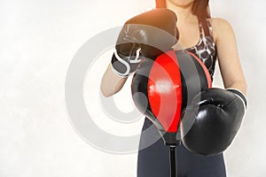 Woman wearing boxing gloves near the floor punching bag