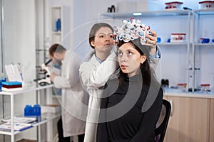 Woman wearing brain wave headset in modern medicine lab with neurologist doctor health physician