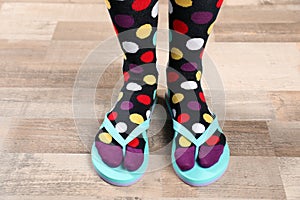 Woman wearing bright socks with flip-flops standing