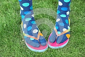 Woman wearing bright socks with flip-flops standing