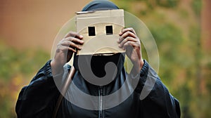 A woman wearing burka holds a piece of paper in front of her face