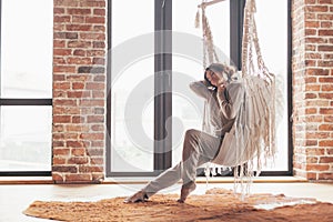 Woman wearing cashmere nightwear relaxing on hammock in cabin photo