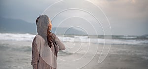 Woman wearing casual clothing enjoying sea storm and water waves of the sea on the beach