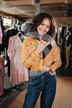 Woman wearing casual denim jaket posing in the fashion store