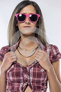 Woman wearing checkered shirt and pink sunglasses