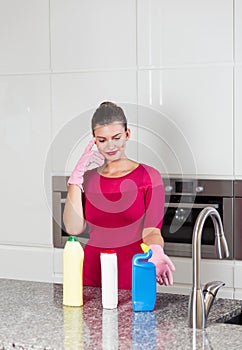 Woman wearing cleaning gloves standing in a kitchen