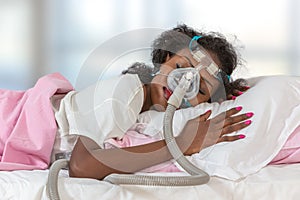 Woman wearing CPAP headgear to sleep against apnea photo
