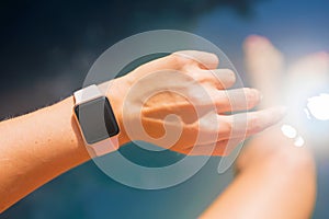 Woman wearing digital watch on hand by the pool