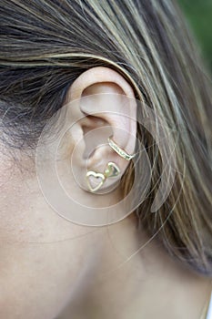 Woman wearing earrings. Earrings at the ear of young woman, women's accessories, gold earrings