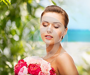 Woman wearing earrings and holding flowers