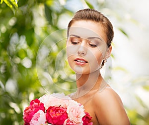 Woman wearing earrings and holding flowers