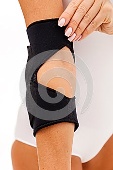 A Woman Wearing Elbow Brace Over White Background