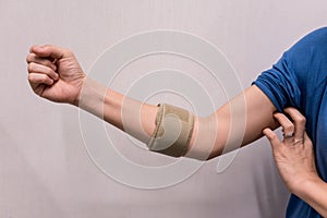 Woman wearing elbow brace to reduce pain