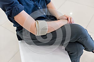 Woman wearing elbow brace to reduce pain