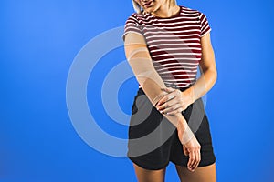 woman wearing an elbow support brace on a blue background, copy space trauma and healing concept