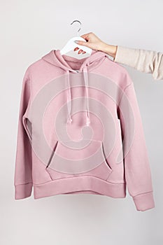 Woman wearing empty pink hoodie in hand, mockup for your own design