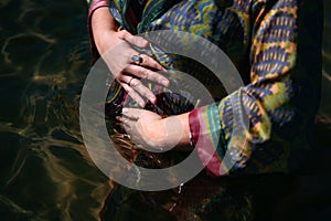 Woman wearing a fabric silk bathrobe half submerge in the water