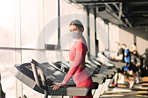 Woman wearing face mask exercise workout in gym during corona virus pandermic