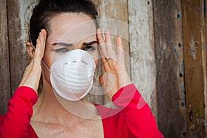 Woman wearing a face mask has a headache