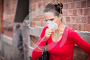 Woman wearing facemask coughing