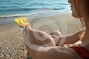 Woman wearing flippers near sea on beach