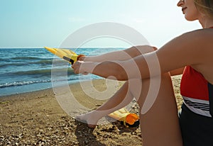 Woman wearing flippers near sea on beach, closeup