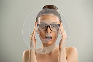 Woman wearing glasses and looking surprised