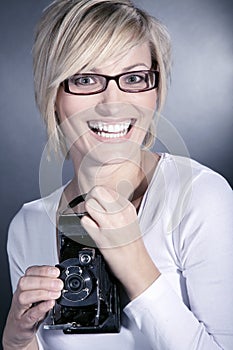 Woman wearing glasses with old retro camera